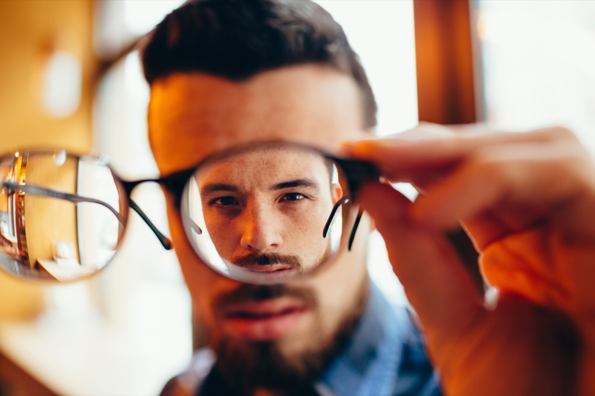 guy is holding his eyeglasses