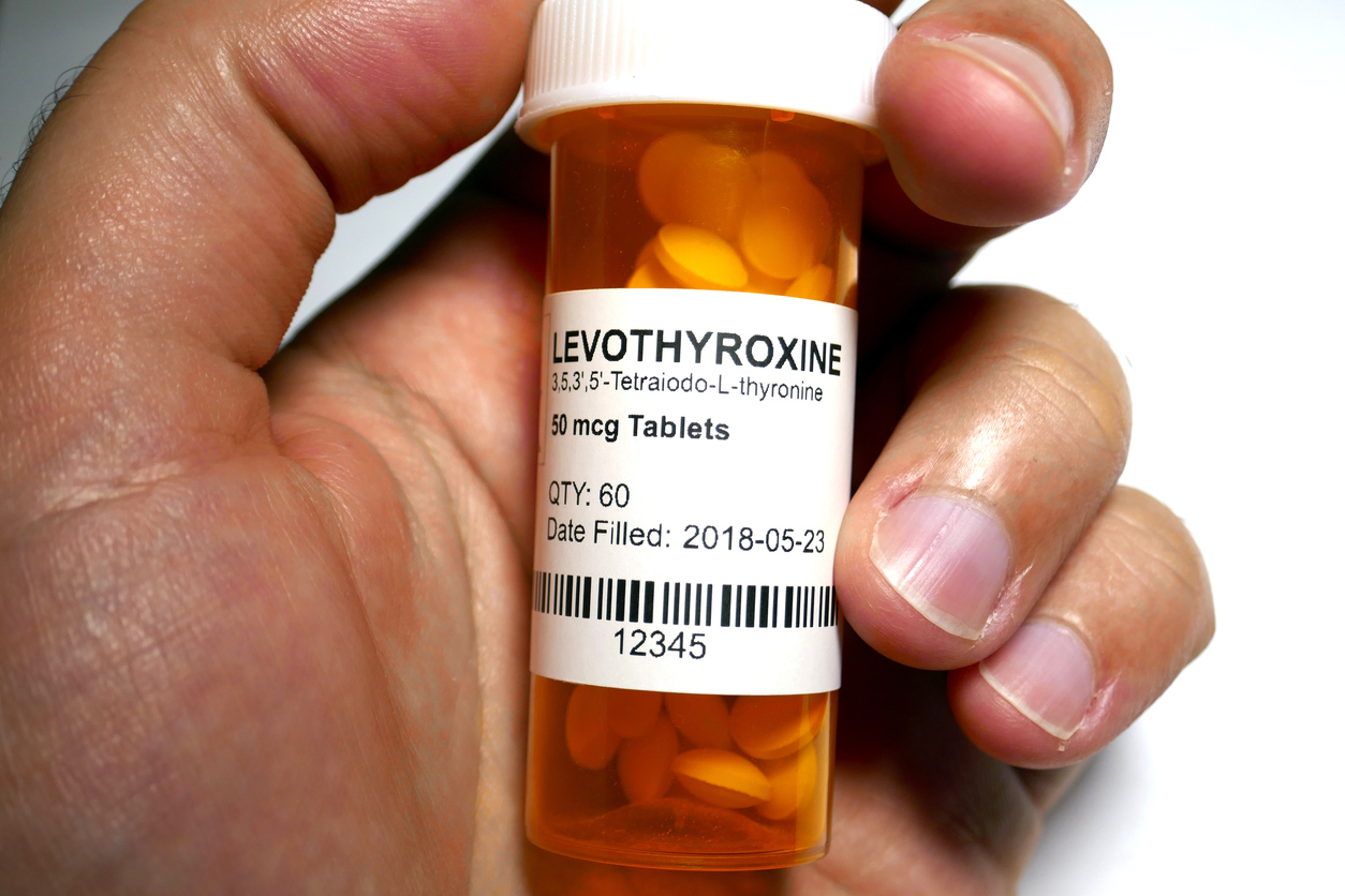 Hand holding bottle of Levothyroxine.