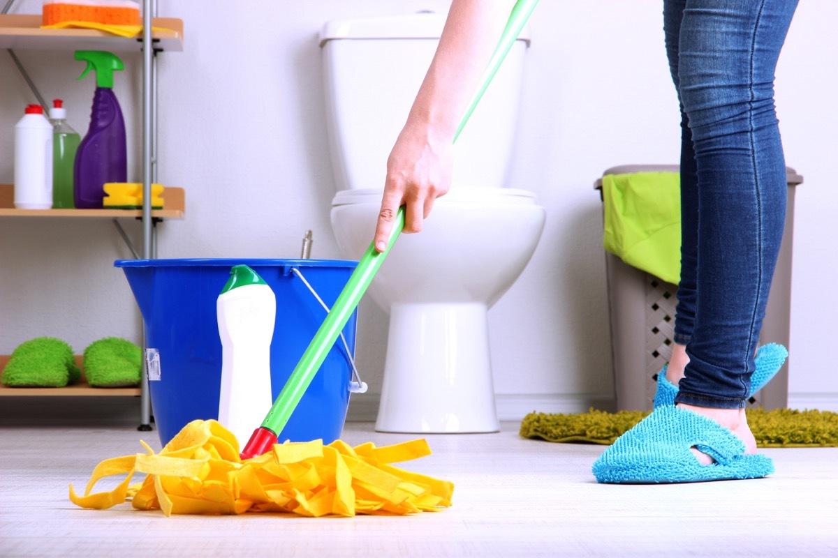 Mopping bathroom floor in slippers