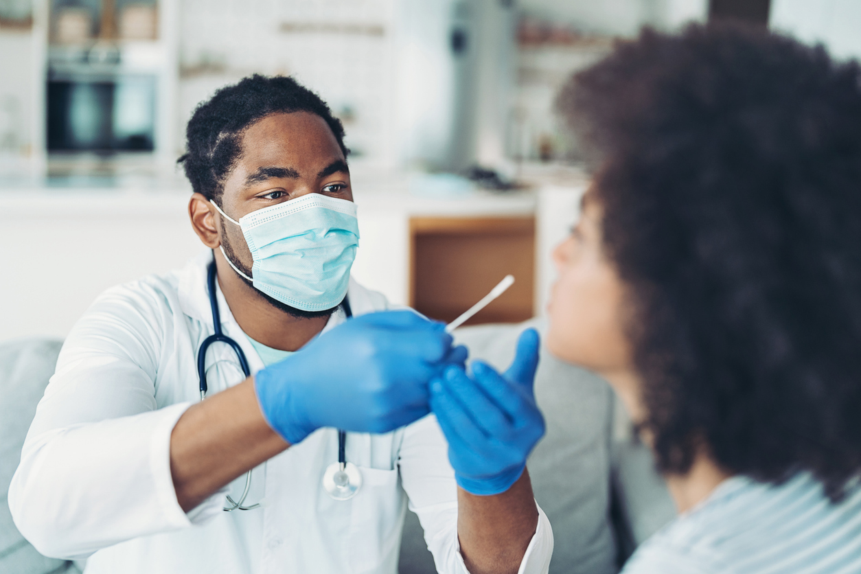 A doctor administering a nasal swab for a COVID test on a young woman