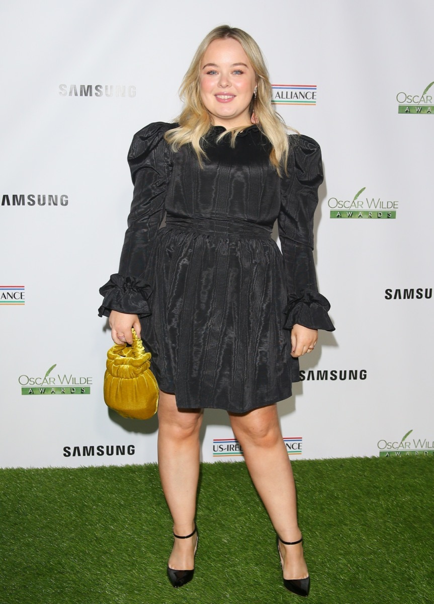 nicola coughlan in a black dress on the red carpet in front of a step-and-repeat