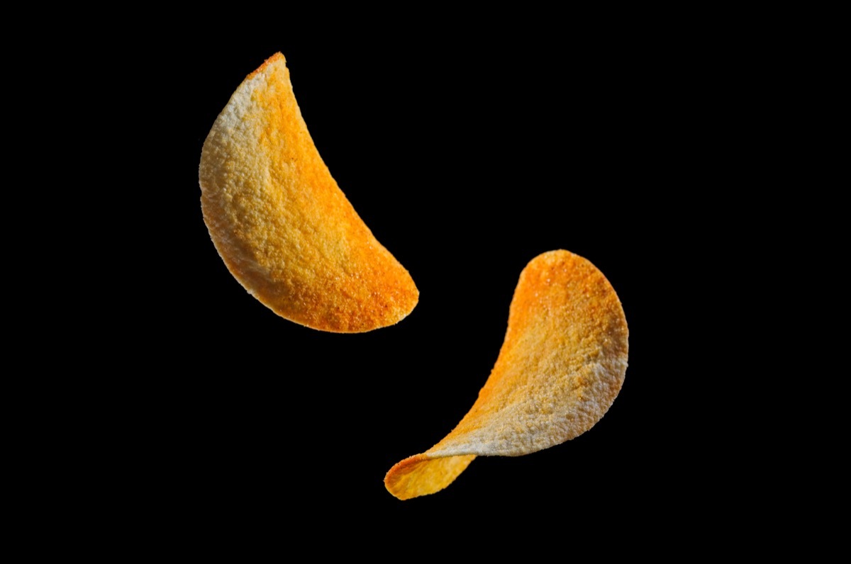 free-floating pringles against a black background