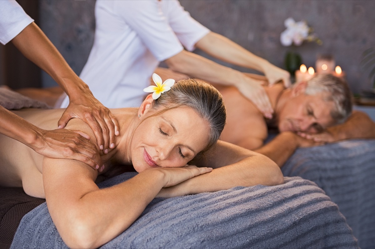 Senior couple in spa salon getting massage. Relaxed senior couple enjoying body treatment in a wellness center. Retired man and woman receiving a back massage from masseur in a spa salon. (Senior couple in spa salon getting massage.